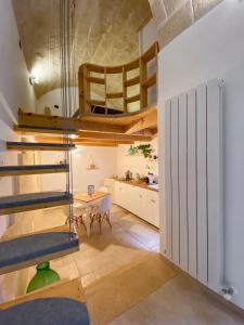 een kamer met een trap, een tafel en een keuken bij Al Chiasso 12 in Monopoli