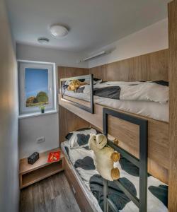 een slaapkamer met 2 stapelbedden en een teddybeer op een plank bij Vila Vernig in Bled