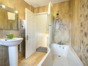 a bathroom with a sink and a tub and a shower at Pass the Keys Fab Townhouse Near Queens with Huge TV & Recliners in Belfast +27 photos