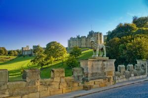 eine Löwenstatue vor einem Schloss in der Unterkunft Pol!cehouse Cottages, Embleton in Alnwick + 4 Fotos