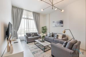 a living room with a couch and a table at Stunning 1BR at Prime Views Meydan by Deluxe Holiday Homes in Dubai