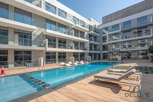a swimming pool in front of a building at Stunning 1BR at Prime Views Meydan by Deluxe Holiday Homes in Dubai
