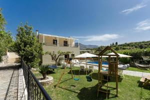 a house with a yard with a playground and a pool at Villa Elodia with Pool & Garden in Heart of Crete in Avdhellás