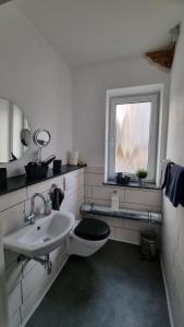 ein Bad mit einem Waschbecken, einem WC und einem Fenster in der Unterkunft Kohle und Stahl in Hattingen