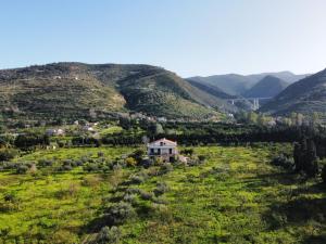 a house in a field with mountains in the background at Tenuta Piana 2 con accesso diretto al mare in Caronia