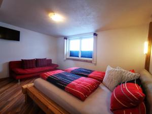 a room with a bed and a couch and a window at Haus Maria Larcher in Bach