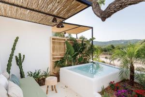 una bañera de hidromasaje en medio de un patio con plantas en Agroturismo Can Domo, en Santa Eulària des Riu