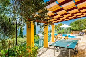 eine Terrasse mit einem Tisch und einem Pool in der Unterkunft Villa Selini in Nisaki