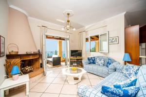 sala de estar con sofás azules y chimenea en Villa Selini, en Nisakion