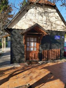 a small house with a wooden door and a fence at Kuća za odmor Tupek in Zagreb