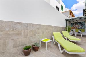 a patio with green cushioned chairs and a table at Cordel 18 in Playa Honda