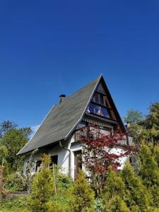 uma casa com um telhado preto e uma varanda em Finnhütte Wolfsburg em Wolfsburg-Unkeroda