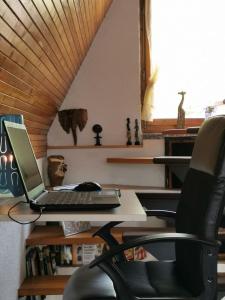 a laptop computer sitting on a desk with a chair at Finnhütte Wolfsburg in Wolfsburg-Unkeroda