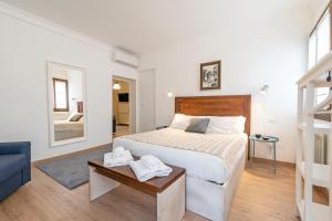 a white bedroom with a bed and a blue couch at San Marco Schiavoni apartments in Venice