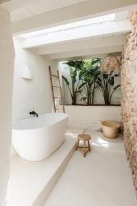 baño con bañera blanca y silla en Agroturismo Can Domo, en Santa Eulària des Riu