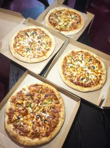 4 pizze sedute in scatole su un tavolo di Lake Villa a Habaraduwa Central