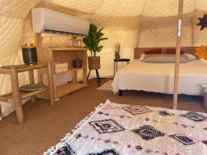 a bedroom with a bed and a rug in a yurt at Glamping -420 in Kalia