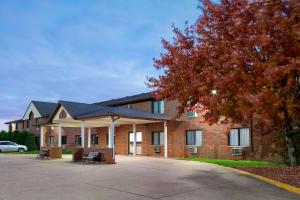 a large brick building with a tree in front of it at Howard Johnson by Wyndham Waterloo/Cedar Falls in Waterloo