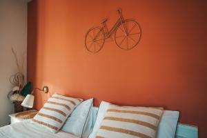una bicicletta appesa a un muro accanto a un letto di Casa di Franz a Vigo di Fassa