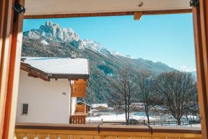 a window with a view of a snowy mountain at Casa di Franz in Vigo di Fassa