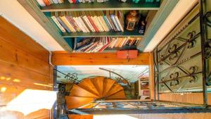 a room with a mirror and a book shelf with books at Chrissi Nefeli in Agios Georgios Nilias