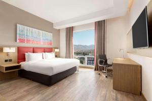 Postel nebo postele na pokoji v ubytování Ramada Encore by Wyndham Muscat Al-Ghubra