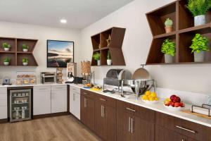 a large kitchen with wooden cabinets and fruits on the counter at Microtel Inn & Suites by Wyndham Antigonish in Antigonish