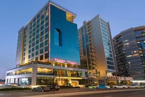 a large blue building with cars parked in front of it at Ramada by Wyndham Dubai Barsha Heights in Dubai