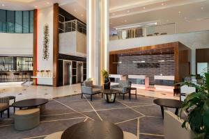 a lobby of a hotel with tables and chairs at Ramada by Wyndham Dubai Barsha Heights in Dubai