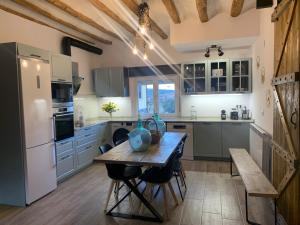 cocina con mesa de madera y nevera en Alojamiento con amplio salón y chimenea., en Valverde