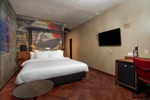 a hotel room with a large bed and a desk at Inntel Hotels Amsterdam Landmark in Amsterdam