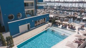 una vista aérea de una piscina en un edificio con puerto deportivo en Mosella Suite Hotel, en Sottomarina