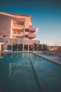 un bâtiment avec une piscine en face d'un bâtiment dans l'établissement Mosella Suite Hotel, à Sottomarina