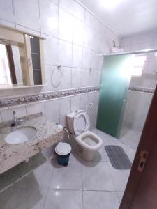a bathroom with a toilet and a sink and a shower at Pousada AJS in Palhoça