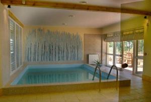 a large swimming pool in a room with at Liedags Guesthouse in Jūrkalne