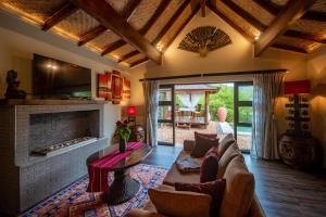 a living room with a couch and a fireplace at The Zarafa in Hazyview