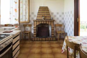 cocina con chimenea, sillas y mesa en LA CASA DE FASCIA' Contrada pescara valle, en Monte San Pietrangeli