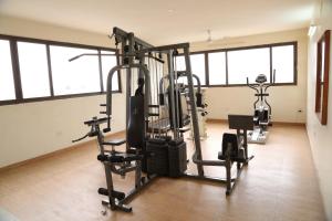 a gym with several tread machines in a room at Hotel Western Gatz in Theni