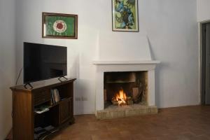 salon z kominkiem i telewizorem w obiekcie CASA LELLA Monte San Pietrangeli w mieście Monte San Pietrangeli