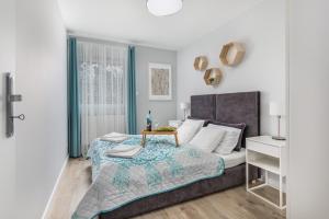 a bedroom with a large bed and a table at Apartamenty Wczasowa by Renters in Międzywodzie