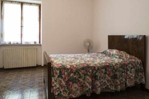 una camera da letto con un letto con copriletto floreale e 2 finestre di LA CASA DE FASCIA' Contrada pescara valle a Monte San Pietrangeli