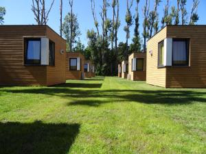 a row of cottages on a lawn with trees at Sopot 34 przy plaży in Sopot