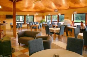 un restaurante con mesas y sillas y personas sentadas en mesas en Liedags Guesthouse, en Jūrkalne