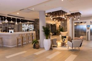 a restaurant with a bar with chairs and a counter at Hilton Garden Inn Le Havre Centre in Le Havre
