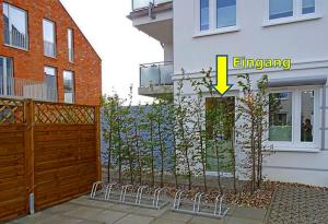 ein Gebäude mit einem Zaun mit einem gelben Pfeil darauf in der Unterkunft Appartement Fienchen 1 SZ Terrasse by Unsere Urlaubszeit in Kellenhusen