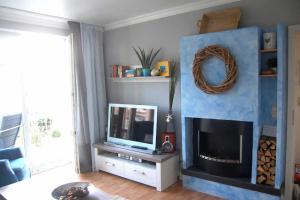 a living room with a tv and a fireplace at Haus Jahreszeiten Appartement Meeresrauscher by Unsere Urlaubszeit in Binz