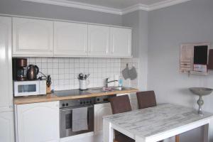 a kitchen with white cabinets and a counter top at Haus Jahreszeiten Appartement Meeresrauscher by Unsere Urlaubszeit in Binz