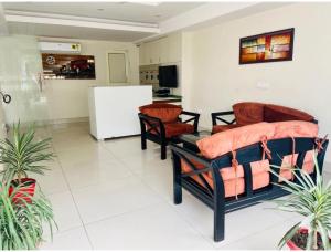 sala de estar con 2 sillas y nevera en BluO Studio4 Golf Course Road - Gym, Balcony, Lift en Gurgaon