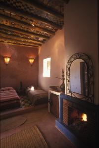 um quarto com uma lareira, uma cama e um espelho em Riad Cascades d'Ouzoud em Cascatas de Ouzoud