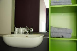 een badkamer met een witte wastafel en een spiegel bij Focus Budget in Kortrijk